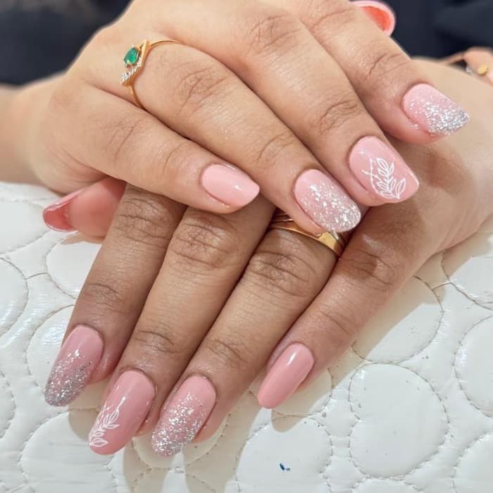 Pink gel nails with white botanical art, done at Ezra's Nail Studio